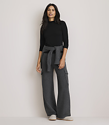 A woman in a black mock-neck top and gray wide-leg cargo pants stands against a plain, light-colored background. carousel Product Image 2