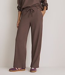 A person stands in brown waffle-knit pants and purple sneakers against a plain, light background. carousel Product Image 2