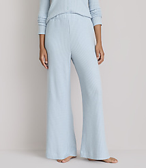 A person stands in light blue waffle-knit pajamas, with the background a plain, light gray. carousel Product Image 2