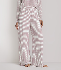 A person stands wearing striped pajama pants and a matching top against a plain white background. carousel Product Image 2