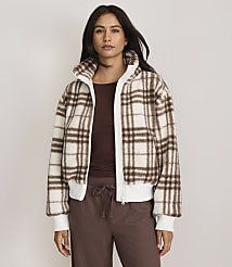 A woman in a plaid jacket and brown pants stands against a plain, light-colored background. carousel Product Image 2