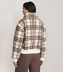 A woman in a brown and white plaid jacket stands against a plain, light-colored background. carousel Product Image 3