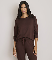 A woman in a brown long-sleeved shirt and pants stands against a plain, light gray background. carousel Product Image 1