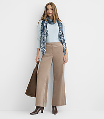 A woman in a light blue sweater, patterned scarf, and tan corduroy pants stands against a plain white background, holding a brown tote bag. carousel Product Image 1