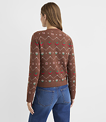 A woman in a brown patterned sweater and blue jeans stands against a plain, light-colored background. carousel Product Image 4