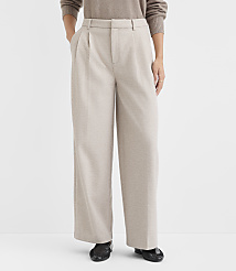 A person stands in the foreground wearing beige pleated wide-leg pants and a brown sweater, against a plain white background. carousel Product Image 2