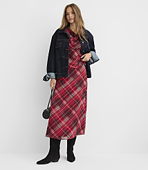 A woman in a plaid dress and denim jacket stands against a plain white background. carousel Product Image 1