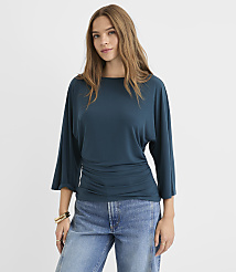 A woman in a teal top and jeans stands against a plain white background. carousel Product Image 1