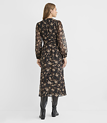 A woman in a floral midi dress and black boots stands against a plain, light gray background. carousel Product Image 3