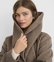 A woman in a brown coat with a large collar is looking forward against a plain background. carousel Product Image 4