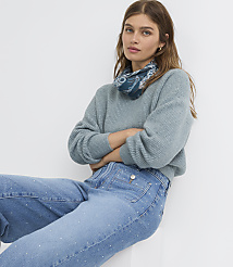 A woman in a light blue sweater and embellished jeans poses against a plain white background. carousel Product Image 4