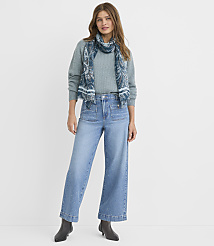 A woman in a teal sweater, patterned scarf, and wide-leg jeans stands against a plain white background. carousel Product Image 1
