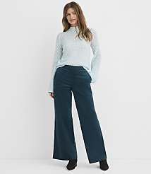 A woman in a light blue patterned sweater and teal wide-leg corduroy pants stands against a plain white background. carousel Product Image 1