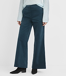 A person stands in teal corduroy flared pants and a light blue sweater, with a plain white background. carousel Product Image 2