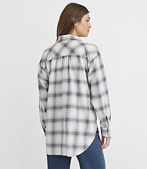 A woman in a grey and white plaid shirt stands against a plain white background. carousel Product Image 4