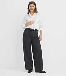 A woman in a white button-down shirt and wide-leg gray pants stands against a plain white background. carousel Product Image 1