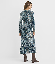A woman in a long, teal paisley-patterned dress and brown boots stands against a plain white background. carousel Product Image 3