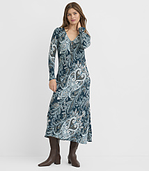 A woman in a long, patterned dress and brown boots stands against a plain white background. carousel Product Image 2
