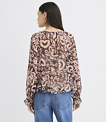 A woman in a floral print blouse and jeans stands against a plain white background. carousel Product Image 3