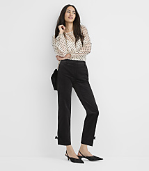 A woman in a polka dot blouse and black corduroy pants with bows at the ankles stands against a plain white background. carousel Product Image 1