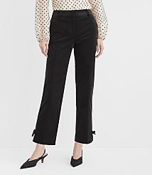 A person stands in front of a plain white background, wearing black corduroy pants with bows at the ankles and a polka-dot blouse. carousel Product Image 2