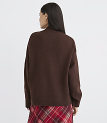 A woman in a brown sweater and plaid skirt stands against a plain white background. carousel Product Image 3