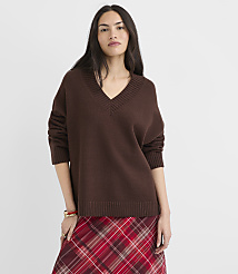 A woman in a brown v-neck sweater and a red plaid skirt stands against a plain white background. carousel Product Image 1