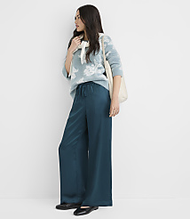 A woman in a patterned sweater and teal wide-leg pants stands against a plain white background. carousel Product Image 1