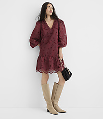 A woman in a burgundy eyelet dress and tan boots poses against a plain white background, holding a black purse. carousel Product Image 2