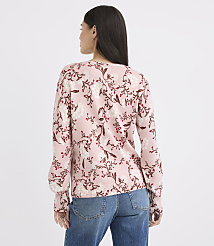 A woman in a pink floral sweater and blue jeans stands against a plain white background. carousel Product Image 3