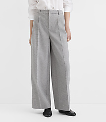 A person stands in wide-leg gray trousers and black shoes against a plain white background. carousel Product Image 2