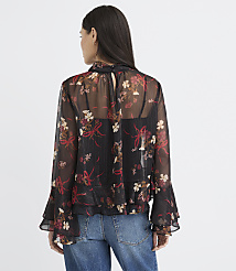 A woman in a sheer floral blouse and jeans stands against a plain white background. carousel Product Image 5