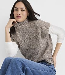 A woman in a textured brown sweater vest and blue jeans poses against a plain white background. carousel Product Image 1