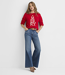 A woman in a red "MERRY" sweater and flared jeans stands against a plain white background. carousel Product Image 3