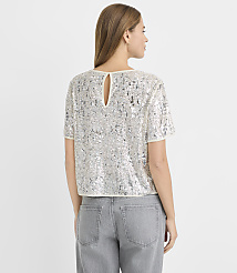 A woman in a sequined top and gray jeans stands against a plain white background. carousel Product Image 3