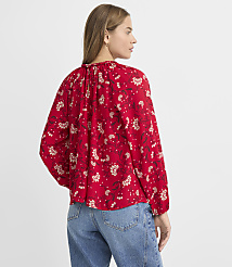 A woman in a red floral blouse and blue jeans stands against a plain white background. carousel Product Image 4