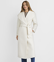 A woman in a cream-colored coat stands against a plain white background. carousel Product Image 2