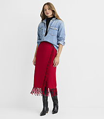 A woman in a denim shirt and a red fringed skirt stands against a plain white background. carousel Product Image 2