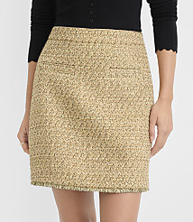 A woman models a textured tweed mini skirt with frayed hem in the foreground, against a plain white background. carousel Product Image 2