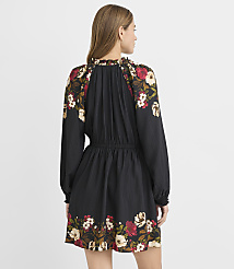 A woman in a black floral-patterned dress stands against a plain white background. carousel Product Image 3