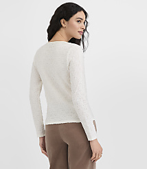 A woman in a cream-colored textured sweater and brown pants stands against a plain white background. carousel Product Image 3