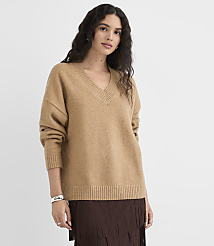 A woman in a tan v-neck sweater and brown skirt stands against a plain white background. carousel Product Image 1