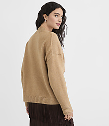 A woman in a tan sweater and brown skirt stands against a plain, light background. carousel Product Image 3