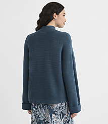 A woman in a teal sweater and patterned skirt stands against a plain white background. carousel Product Image 3