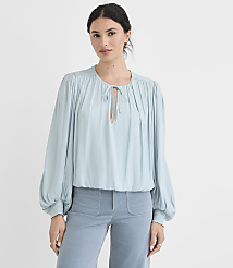 A woman in a light blue blouse and matching pants stands against a plain white background. carousel Product Image 1