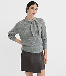 A woman in a grey sweater and dark skirt stands against a plain white background. carousel Product Image 2