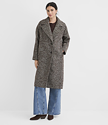 A woman in a textured brown coat and wide-leg jeans stands against a plain white background. carousel Product Image 2