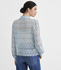 A woman in a light blue lace top and jeans stands against a plain white background. carousel Product Image 3