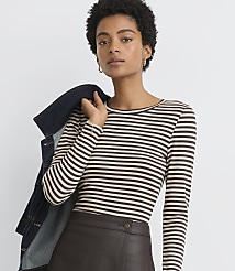 A woman in a striped shirt and leather skirt poses with a denim jacket draped over her shoulder against a plain background. carousel Product Image 2