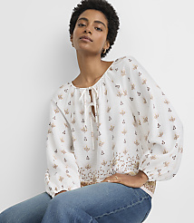 A woman in a patterned blouse and jeans poses against a plain white background. carousel Product Image 2